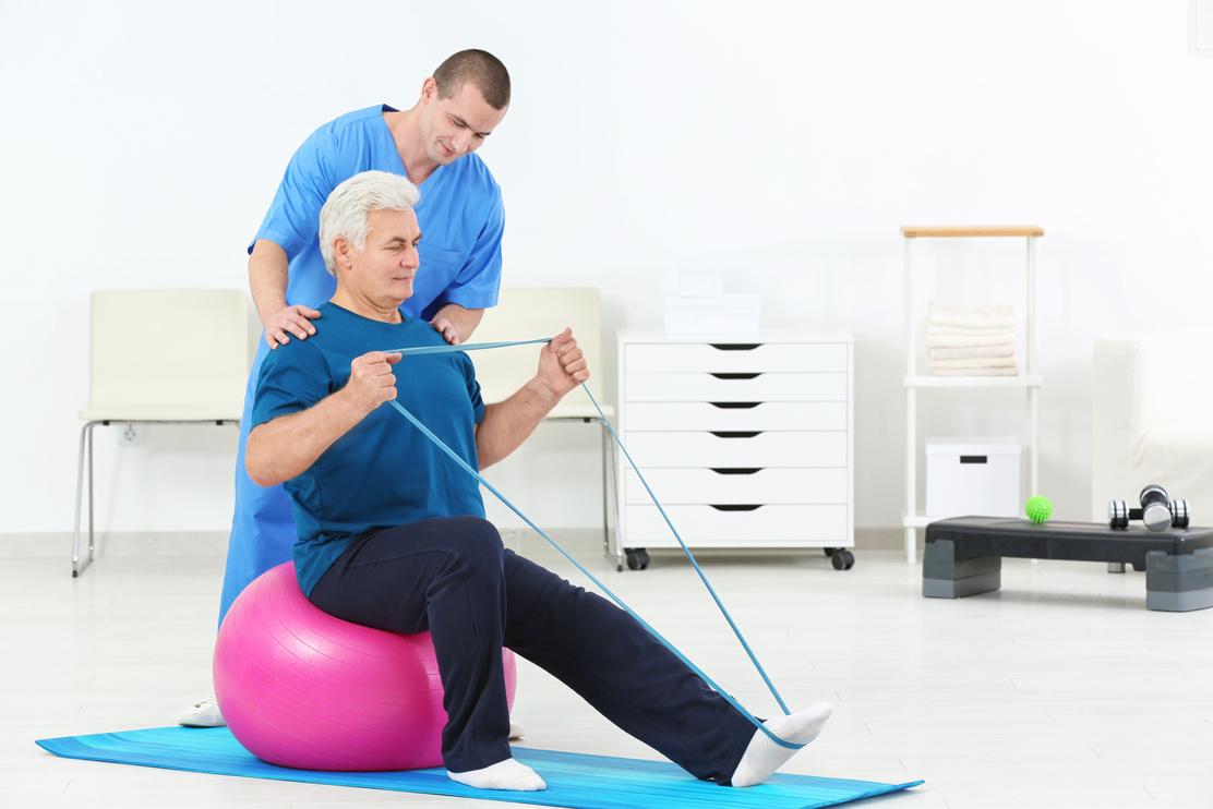 Physiotherapist Working with Elderly Patient in Rehabilitation Center